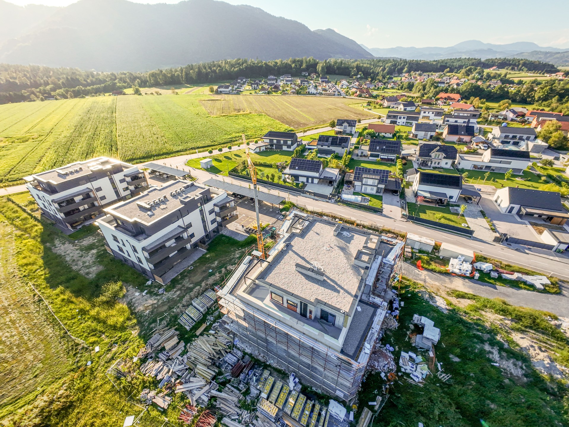 New complex of apartment buildings under construction, aerial view at sunset