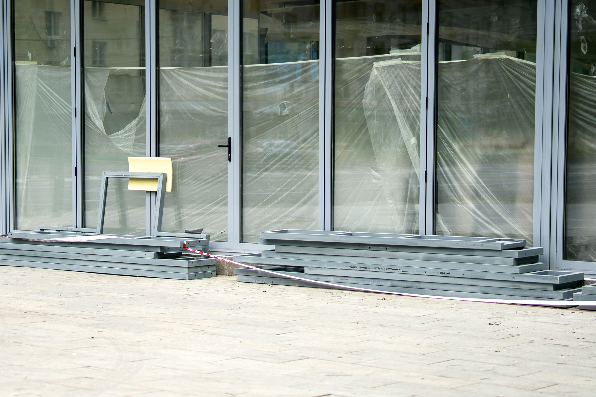 retail store with expansive glass walls stands under renovation, symbolizing transformation and the evolving nature of commerce. The blend glass construction conveys juxtaposition transparency change